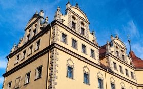 Detailansicht eines historischen Gebäudes mit Fenstern und Verzierungen.