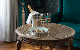 Eleganter Tisch mit Champagner Ein Tisch mit Champagner, Gläsern und einer Schale mit Süßigkeiten.