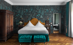 Elegantes Schlafzimmer mit floralem Design Ein stilvolles Schlafzimmer mit einem großen Bett und antiken Möbeln.