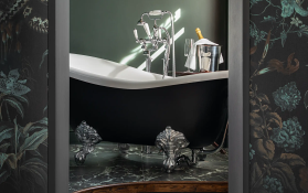 Freistehende Badewanne im Raum Freistehende Badewanne mit silbernen Füßen und Champagner im Hintergrund.